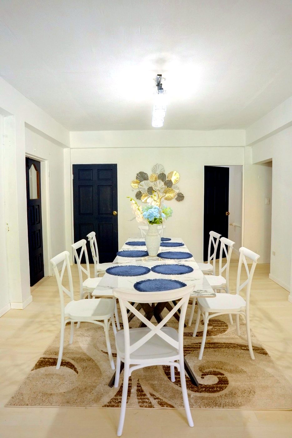 The bright shared dining room at Juniper House, set for a meal with fresh flowers